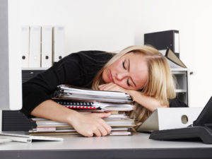 Overworked business woman at work has a headache